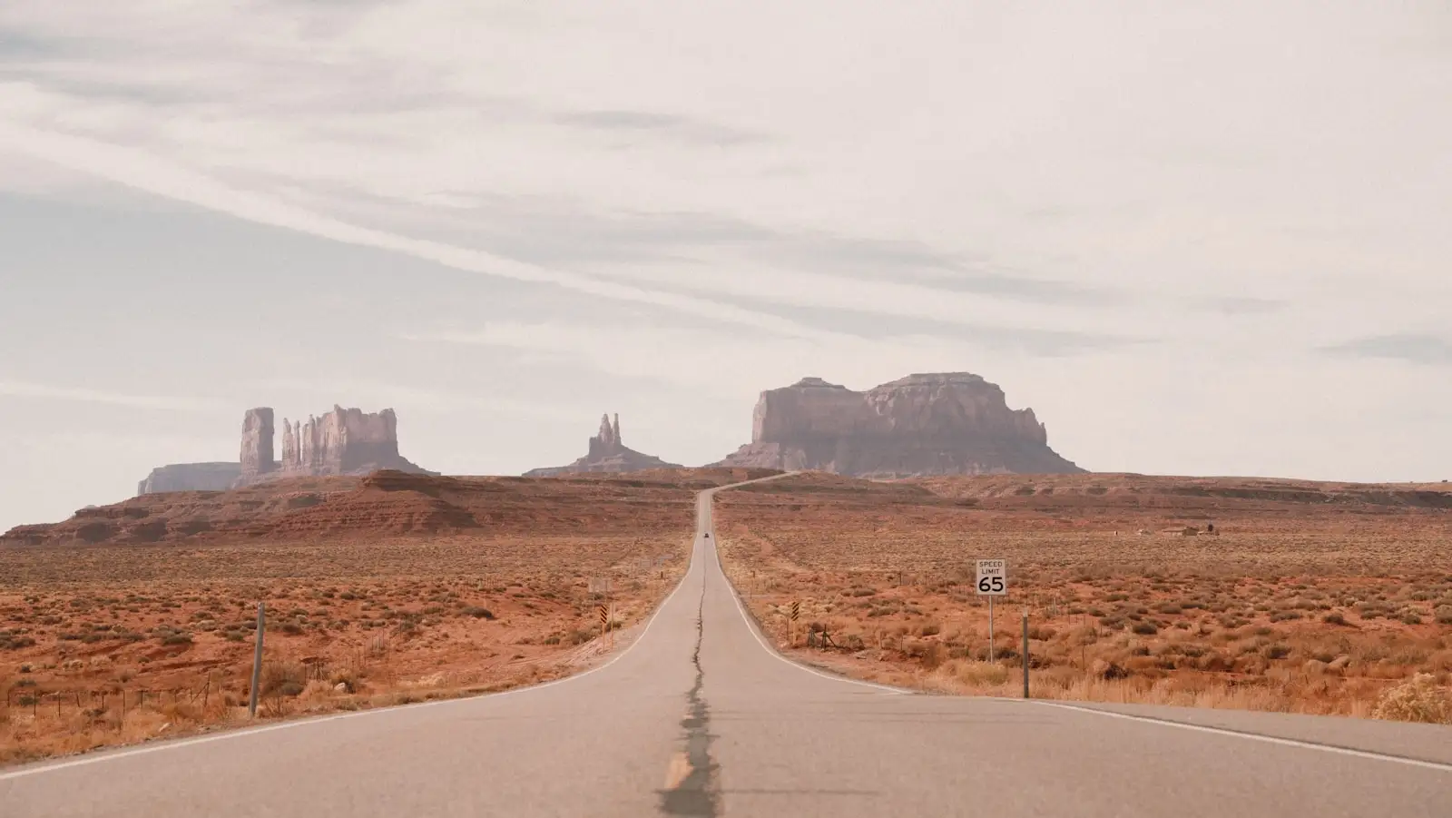 An empty desert highway under a dramatic sky in Monument Valley, Arizona — the broader red-rock country east of Page.